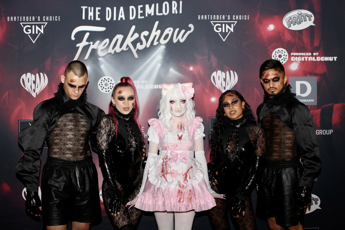 Fünf Gäste in Horror-Kostümen vor dem Freakshow Presswall
