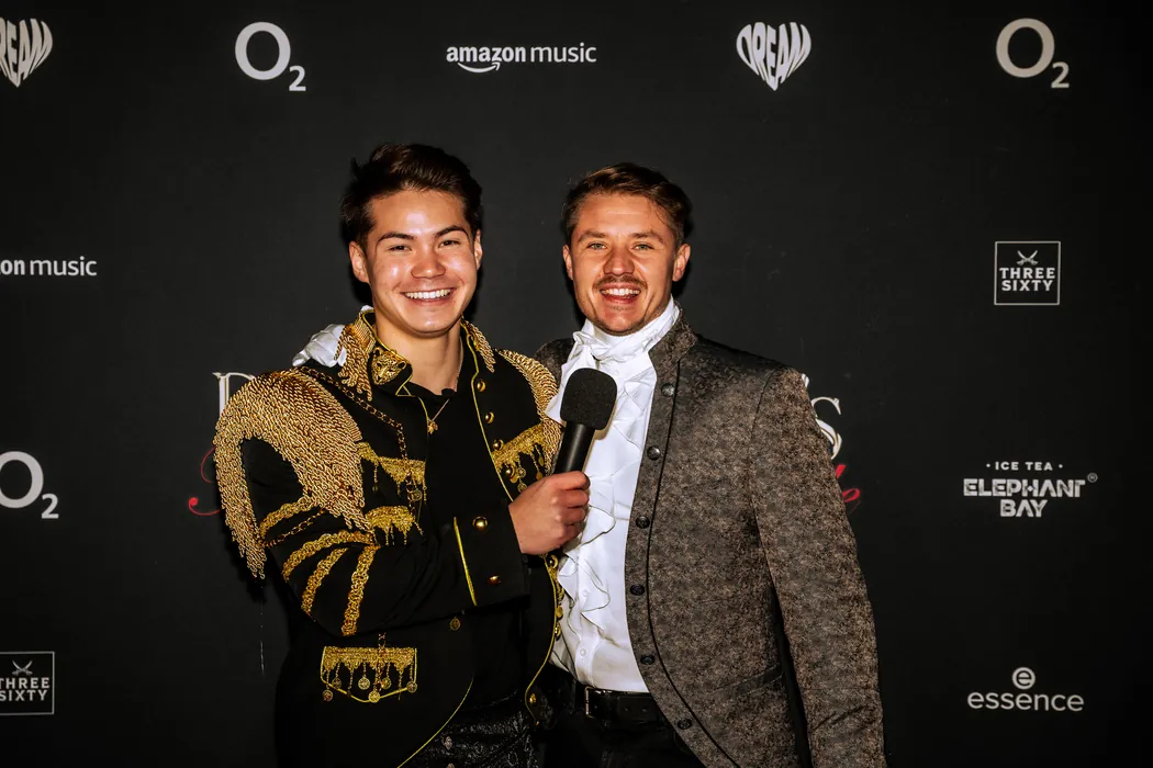Zwei Gäste im goldenen Barock-Look mit Mikrofon