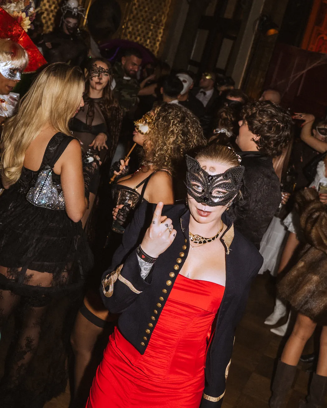 Gäste in Katzenmaske und rotem Kleid