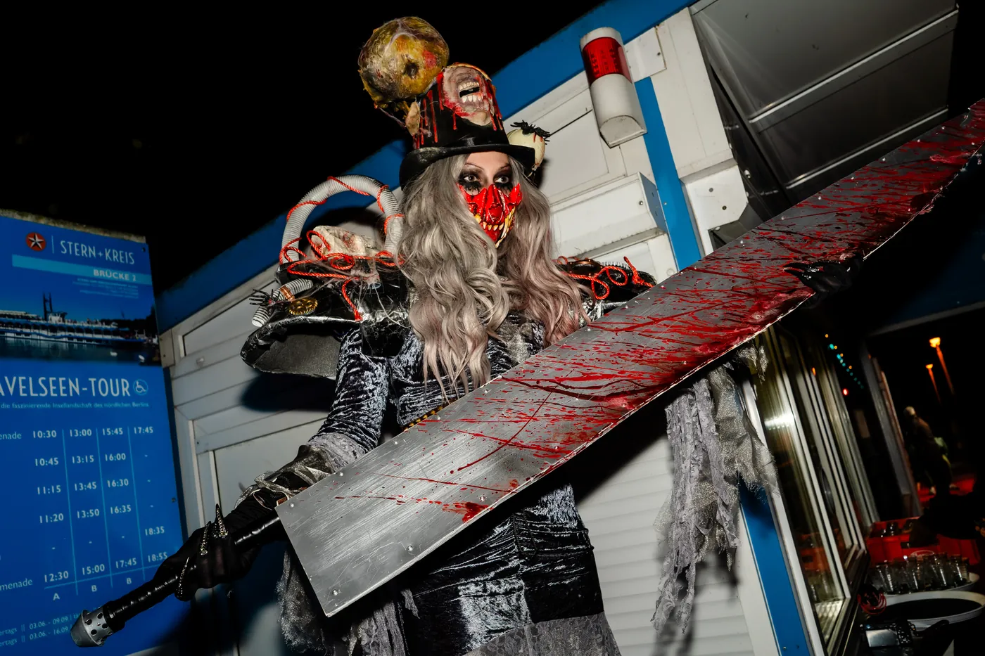 Horror-Entertainerin mit blutigem Schwert am Anleger